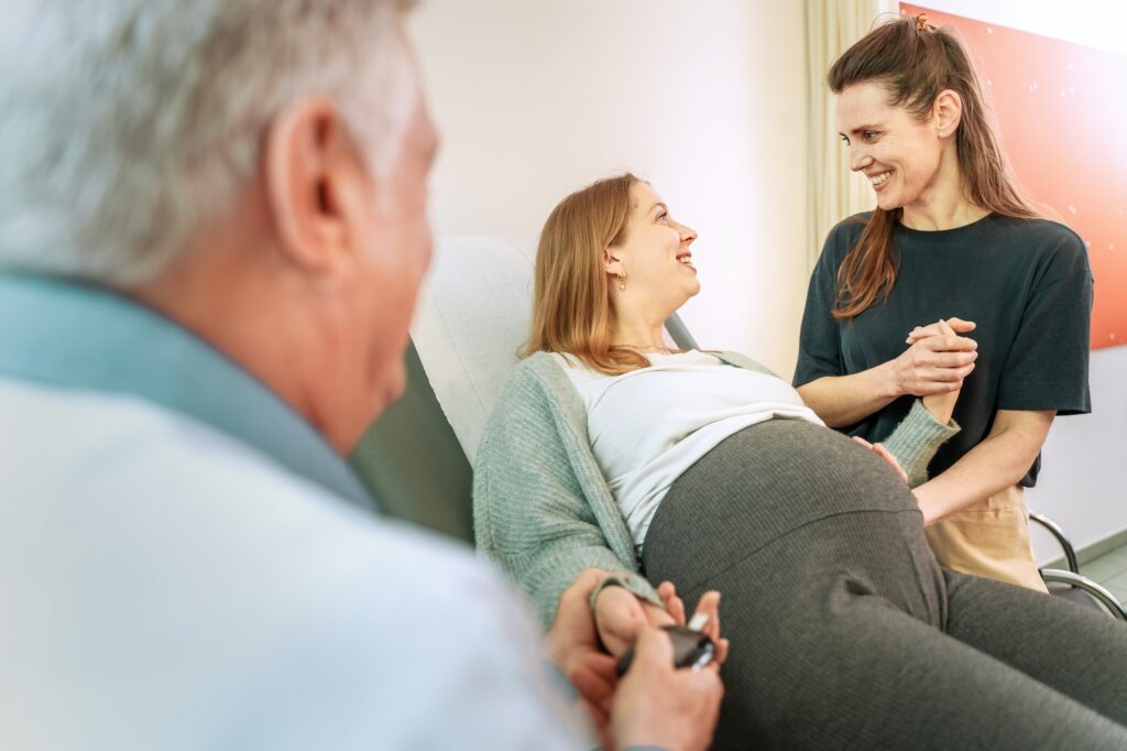 Lesbian Couple of young women with Gynecologist during Pregnancy Checkup