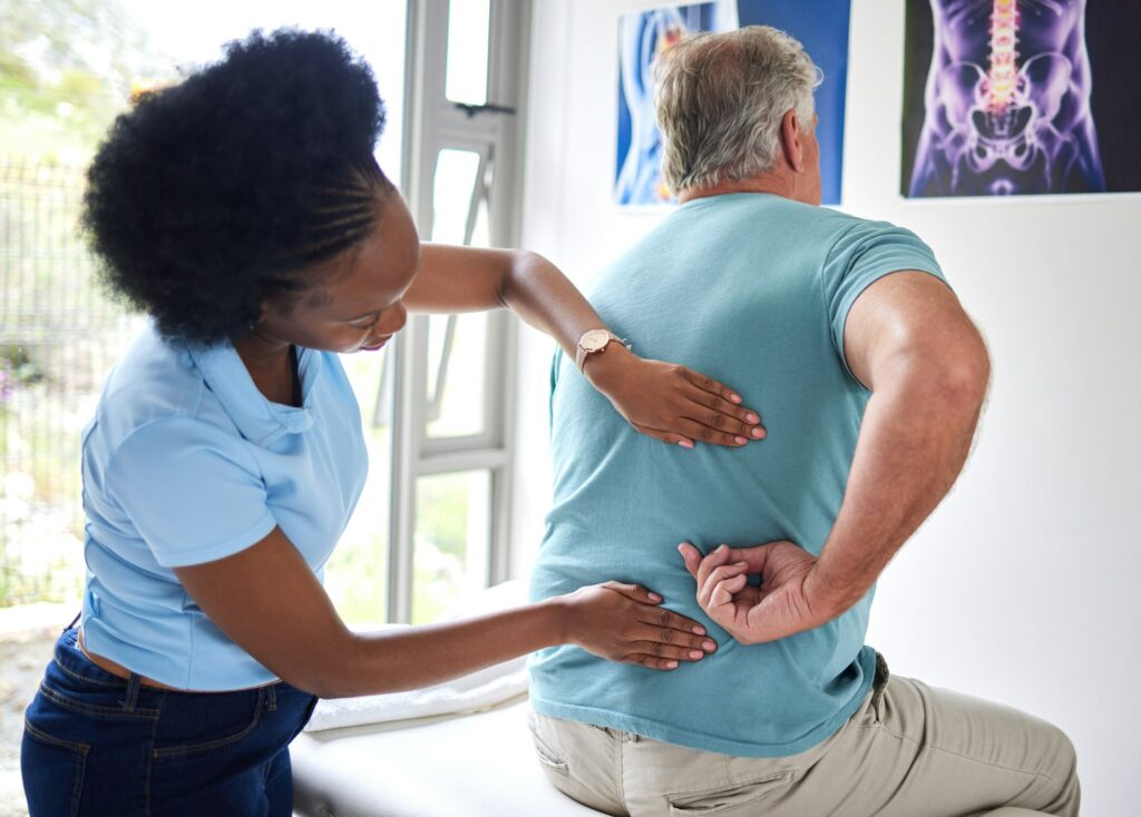 Physiotherapy, chiropractor and senior man with back pain or physiotherapist consulting a patient f